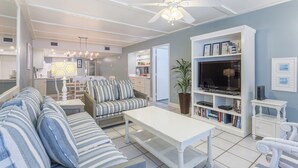 A modern living room with a sofa, coffee table, and bookshelf.
