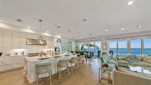 A spacious kitchen with a large island, dining area, and a view of the ocean. - Felicity: Luxury Bayfront Home, Heated Pool, Hot tub and more! (Anna Maria)