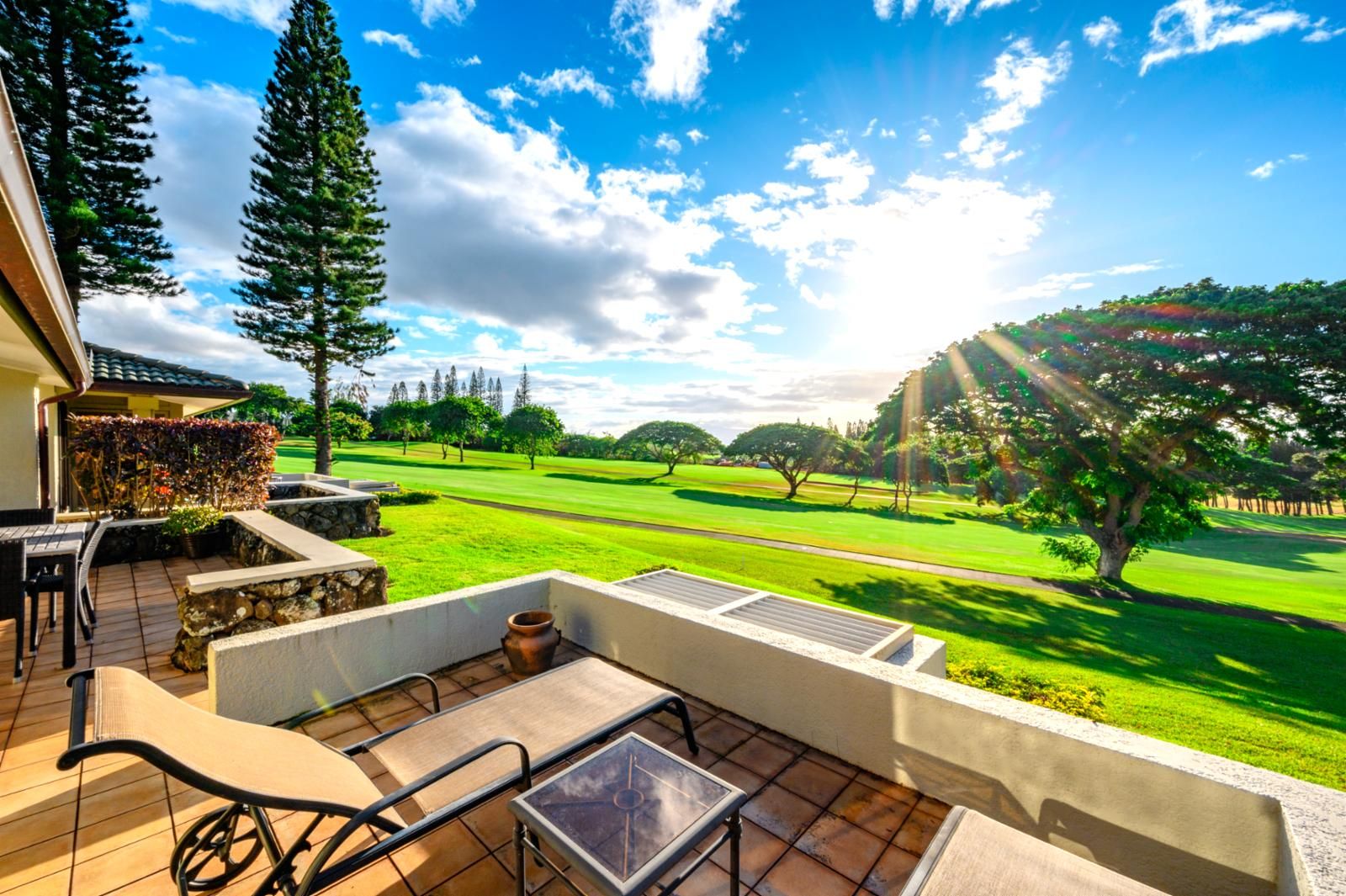 A patio with outdoor furniture overlooking a golf course.