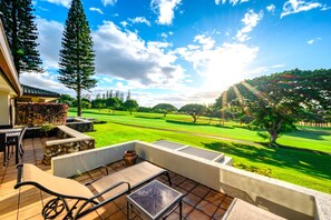 A patio with outdoor furniture overlooking a golf course.