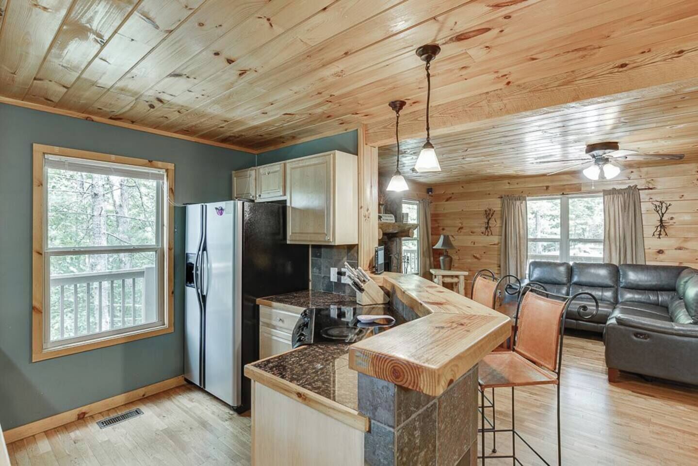 A cabin interior with a kitchen, dining area, and seating space.
