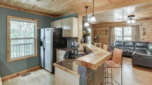 A cabin interior with a kitchen, dining area, and seating space.
