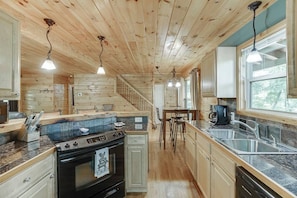 Enjoy cooking in this well-equipped kitchen with a central island, sink, stove, and dining area.