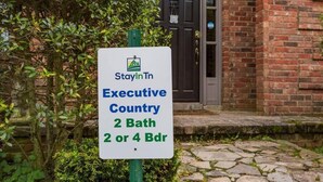 A sign for StayInIn Executive Country, indicating 2-bedroom and 4-bedroom accommodations.