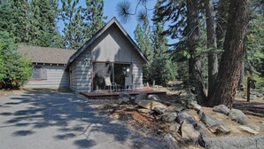 A cabin with a sloped roof, a front porch, and a stone foundation.