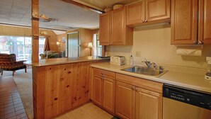 A kitchen with wooden cabinets, a dishwasher, and a sink.