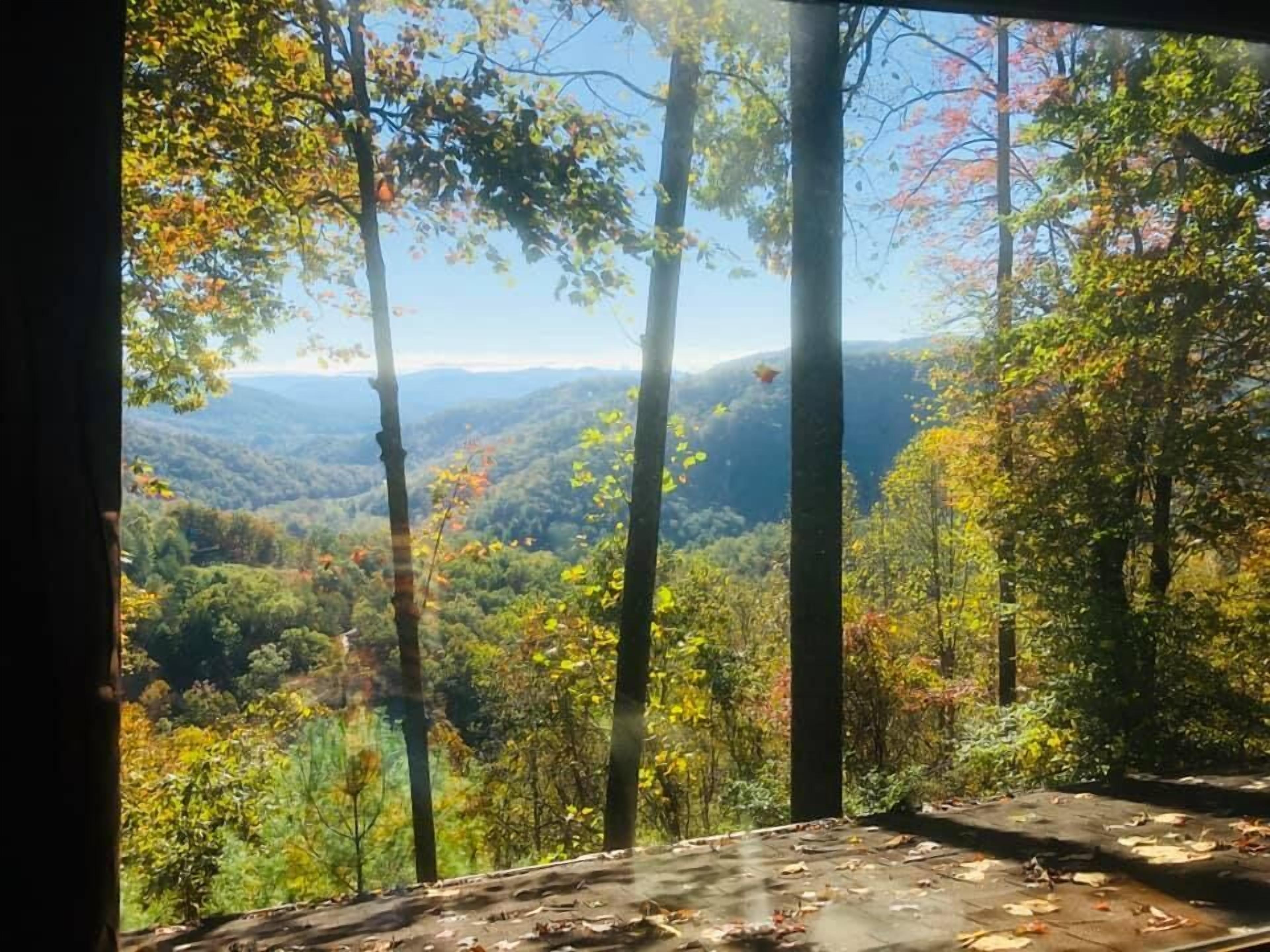 A room with a view of a forested mountain range.