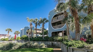 A modern hotel with a curved facade, outdoor pool, and palm trees. - Oceanfront 2BR Resort in St. Augustine (Saint Augustine)