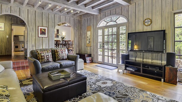 A spacious living room with a large TV, comfortable seating, and a wooden ceiling. - Villa Tranquila ~ Historic Mediterranean Home, Mountain Views, Spa! (Guerneville)