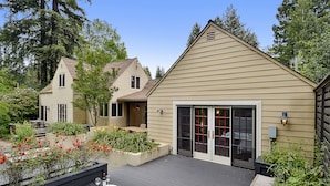 A house with a deck, a hot tub, and a patio area with plants and outdoor furniture. - Villa Tranquila ~ Historic Mediterranean Home, Mountain Views, Spa! (Guerneville)