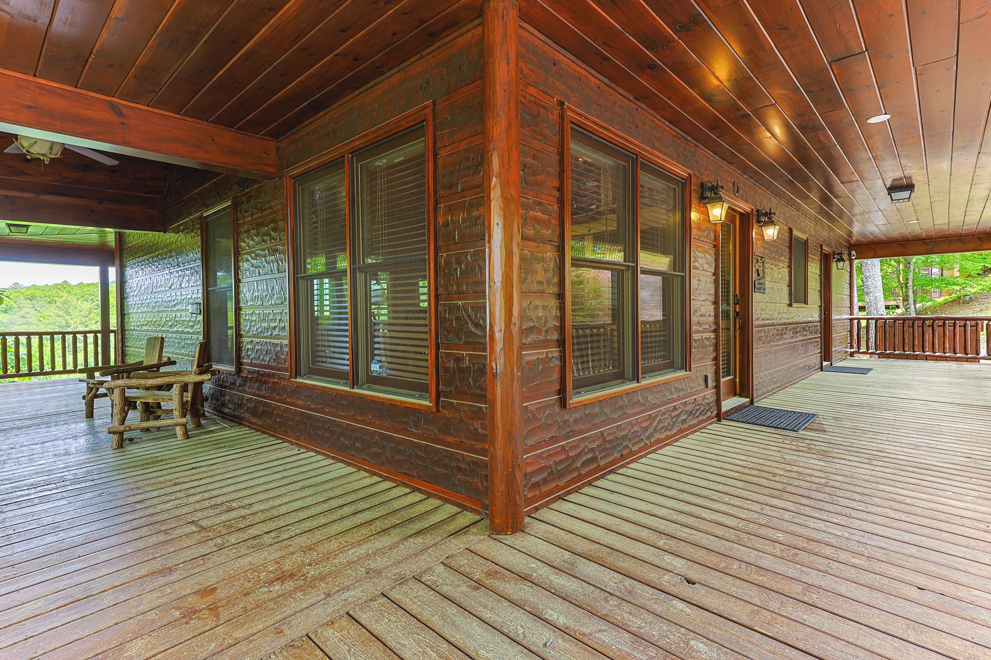 Una cabaña de madera con amplios ventanales, un porche y vistas al exterior.