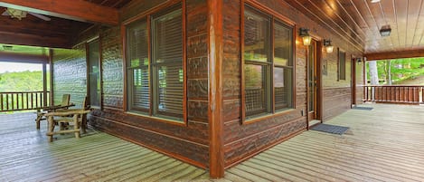 Una cabaña de madera con amplios ventanales, un porche y vistas al exterior.