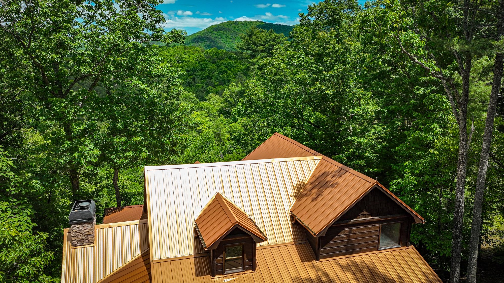 A cabin with a sloped roof, wooden exterior, and a chimney.