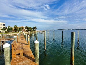 Un muelle de madera que se adentra en aguas tranquilas, bajo un cielo despejado.