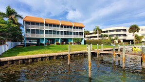 A hotel with a two-story structure, a flat roof, and a pool area with wooden posts.