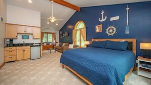 Une chambre dotée d’un grand lit, d’un plafond en bois et d’une décoration sur le thème de la marine.