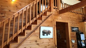 Uma escada de madeira com um quadro de um urso na parede.