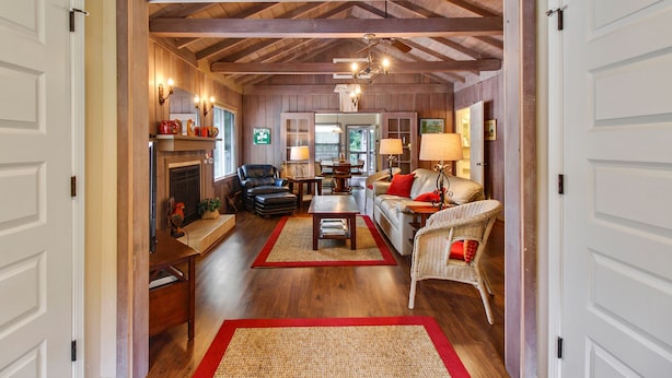 A spacious living room with a fireplace, a sofa, a chair, and a coffee table. - Idle Hours ~ Fantastic River Views & Walk to Downtown! Classic Russian River! (Guerneville)