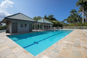 A swimming pool with a tiled deck, a covered seating area, and a small building with a door and windows. - LAST MINUTE DISCOUNT SPECIAL! Central A/C Double Master Suite Home. (Kailua-Kona)