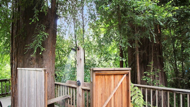 Une terrasse en bois avec une porte en bois et un banc en bois.