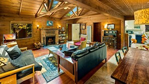 L’intérieur d’un chalet confortable, avec une cheminée, des meubles en bois et un coin repas.