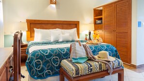 Ein ordentlich eingerichtetes Schlafzimmer mit einem großen Bett, Nachttischen, einem Kleiderschrank und einer Bank mit Hut und Tasche.