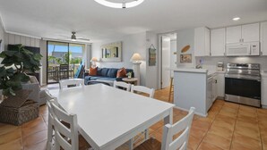 Une cuisine moderne avec des meubles blancs, un four encastré et un four à micro-ondes.