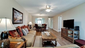 A living room with a sofa set, a coffee table, a TV, and a dining area with chairs and a table. - Gulf Watch 205 - Anna Maria Island - Condo 2 Bedroom / 2 Bath Gulf to Bay access, maximum occupancy of 4 people. (Bradenton Beach)