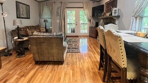 Ein gemütliches Wohnzimmer mit einer Couch, einem Esstisch mit Stühlen und einem Fernseher.