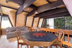 Una habitación acogedora con una mesa a cuadros, vigas de madera y un sofá.