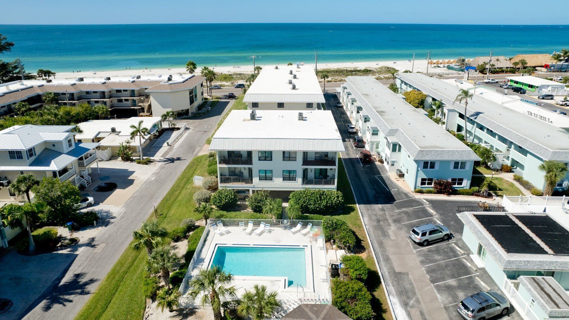 A hotel with a pool, multiple floors, and a view of the beach.