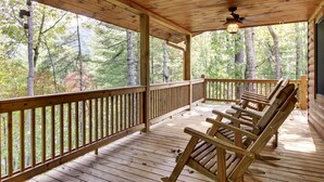A wooden deck with a railing, benches, and a ceiling fan. - CHEROKEE DREAM - SECLUDED MTN VIEW, POOL TABLE, AIR HOCKEY, FIRE PIT, SCREENED PORCH (Epworth)
