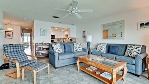 A living room with a blue sofa, a matching armchair, and a coffee table.
