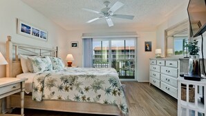 A bedroom with a bed, nightstand, dresser, and a ceiling fan.