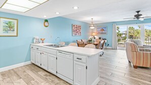 A spacious kitchen with a central island, a dining area with chairs, and a view of the outdoors.