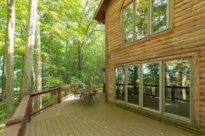 A wooden cabin with a deck, large windows, and a dining area. - Tranquil Dog Friendly Escape w/ Dock Slip (Oakland)