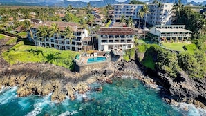 Un resort con varias edificaciones, una piscina y un litoral rocoso.