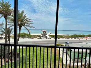 A lifeguard tower overlooking a beach with palm trees and a clear sky.