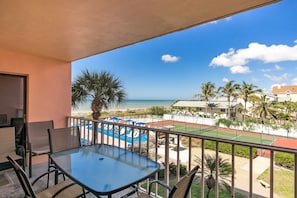 Enjoy the ocean view from this balcony, which offers a clear view of the tennis court and palm trees.