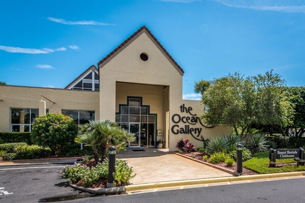 Un bâtiment sur lequel on peut lire l’inscription « The Ocean Gallery » et une autre indiquant « Resort Rentals Clubhouse ».
