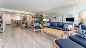 Una sala moderna con un conjunto de sofás, una mesa de centro y un comedor.
