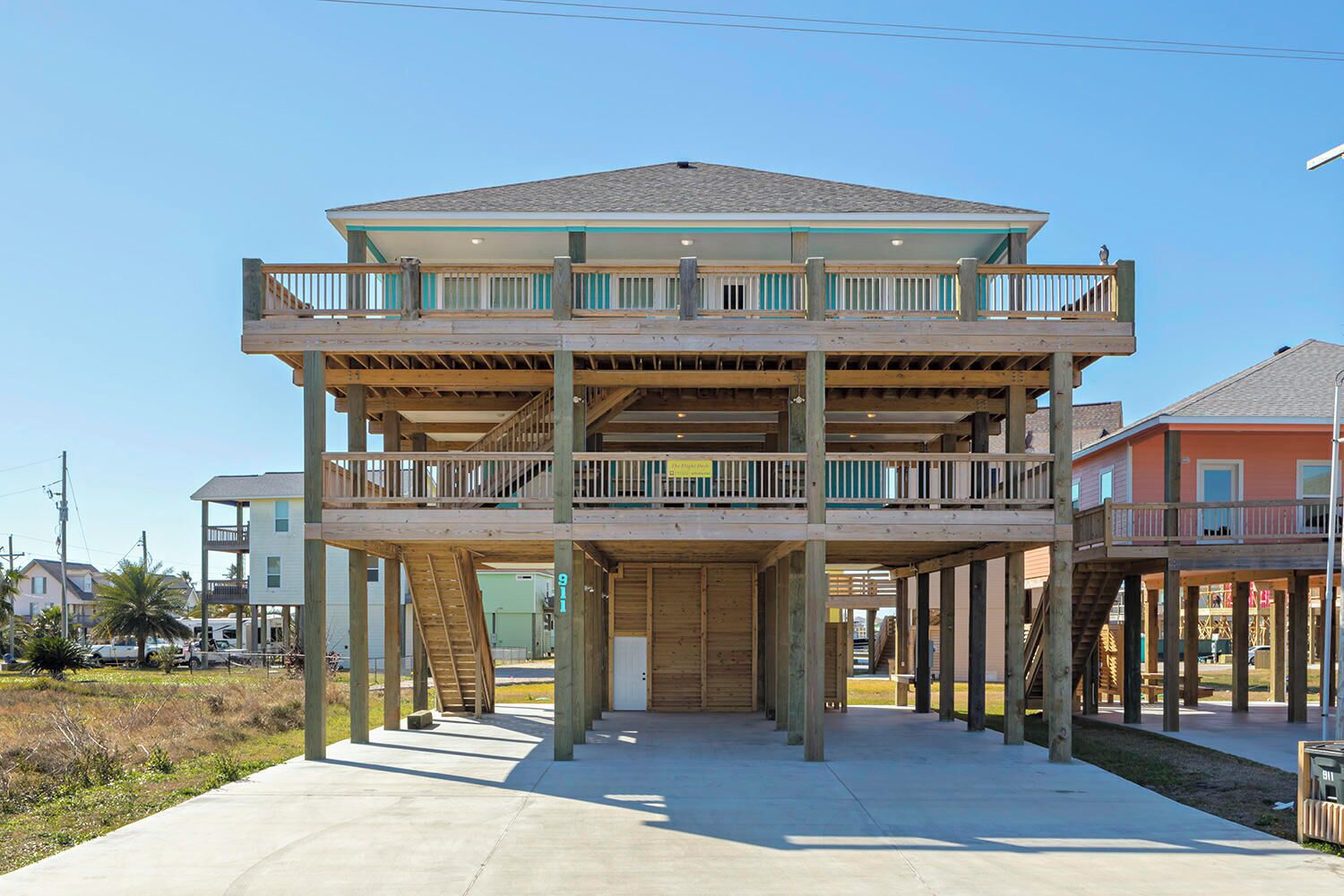 A multi-story building with a wooden deck and a staircase leading to the upper level.