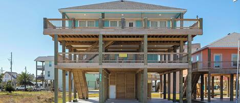 A multi-story building with a wooden deck and a staircase leading to the upper level.