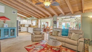 A spacious living area with a high ceiling, a large sofa, a coffee table, and a dining area in the background. - P34 - Beautiful 4 bedroom 2 bath, single family home with private pool and deep water dockage. (Key Colony Beach)