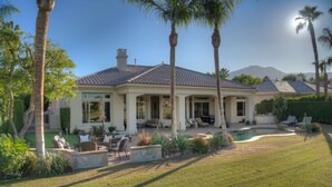 A large house with a swimming pool, outdoor seating, and palm trees. - FALL FLASH SALE -Luxe Pool, Misters Firepit Lounge & Billiards (La Quinta)
