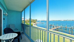 A balcony with a view of a marina and water. - Pelican Cove 12 -  Anna Maria Island - Across the street from the beach- Condo  2 Bedroom /2 Bath bay view with a community pool,  maximum occupancy of 6 people. (Bradenton Beach)