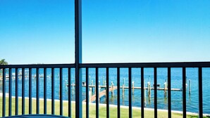 A view from a balcony with a railing, overlooking a marina with docks and boats.