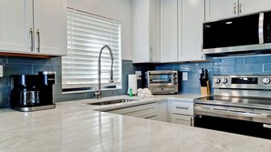 A modern kitchen with a built-in coffee maker, a toaster, and a microwave.