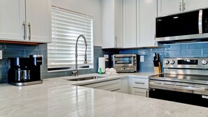 A modern kitchen with a built-in coffee maker, a toaster, and a microwave.