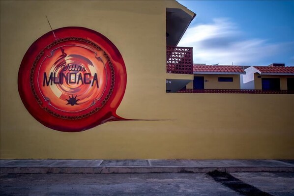 Paredes com um mural de um desenho circular vermelho e o texto 'Tullas Mundaca'.